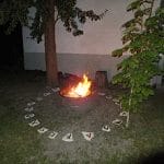A fire pit in the yard with runes on it.
