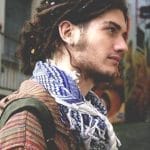 A young man with dreadlocks and a scarf.